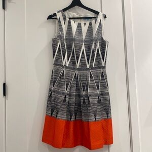 Gorgeous A-line pleated white and black knee length dress with coral hem accent